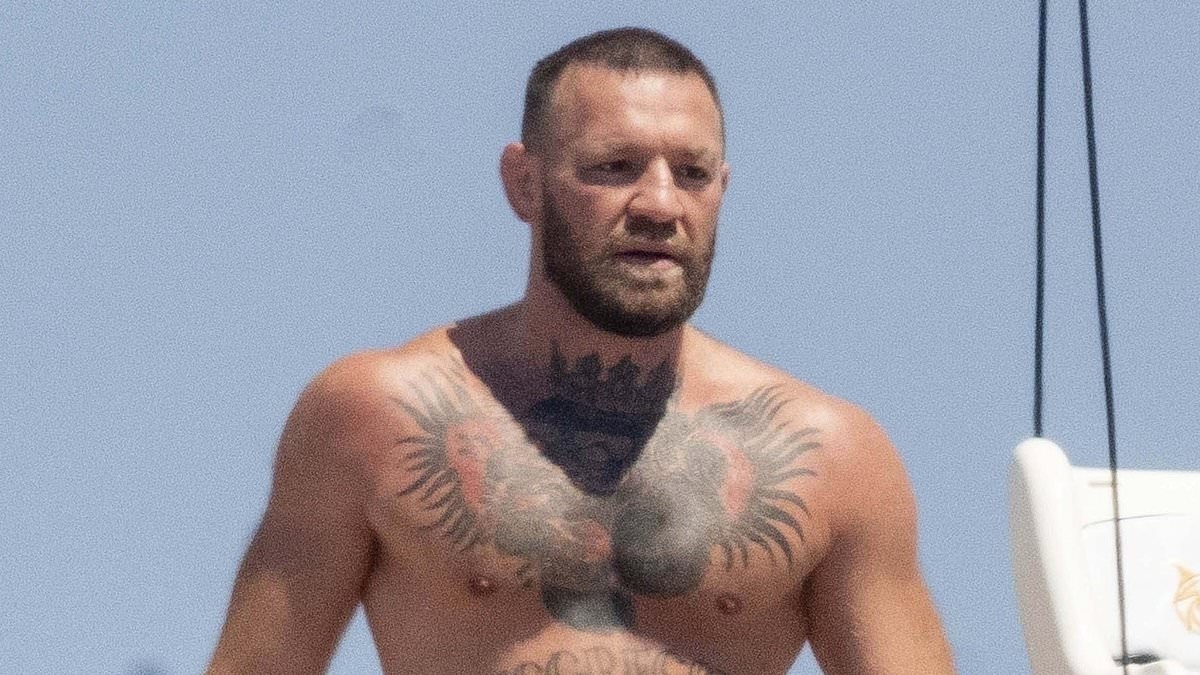 Shirtless Conor McGregor shares a kiss with fiancee Dee Devlin as they show off their affections on loved-up yacht holiday before he leers over her while sunbathing - amid 'cheating' scandal and 'nudes' claims