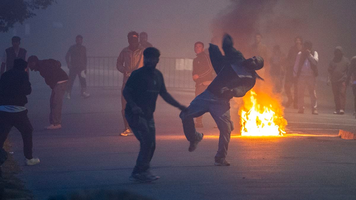 Migrant clashes erupt in northern France with rocks launched at riot cops and fires blazing in the street as police try to stop launch of small boat bound for Britain