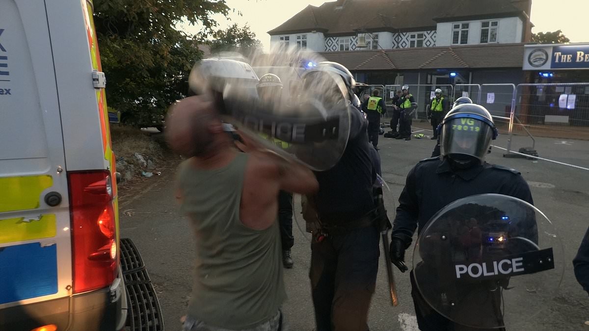 Moment riot police smash shield into man's face, knocking his teeth out during Epping migrant hotel clash after resident was charged with schoolgirl sex attack