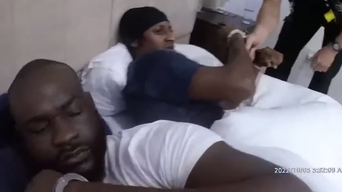 Moment bleary-eyed drug dealers are arrested while sharing a bed after police storm their home in cocaine gang raid