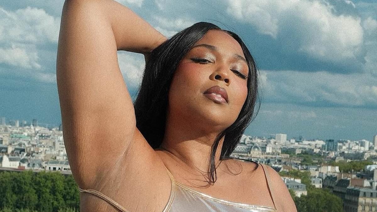 Lizzo jokes while posing in front the Eiffel Tower in figure-hugging metallic gown