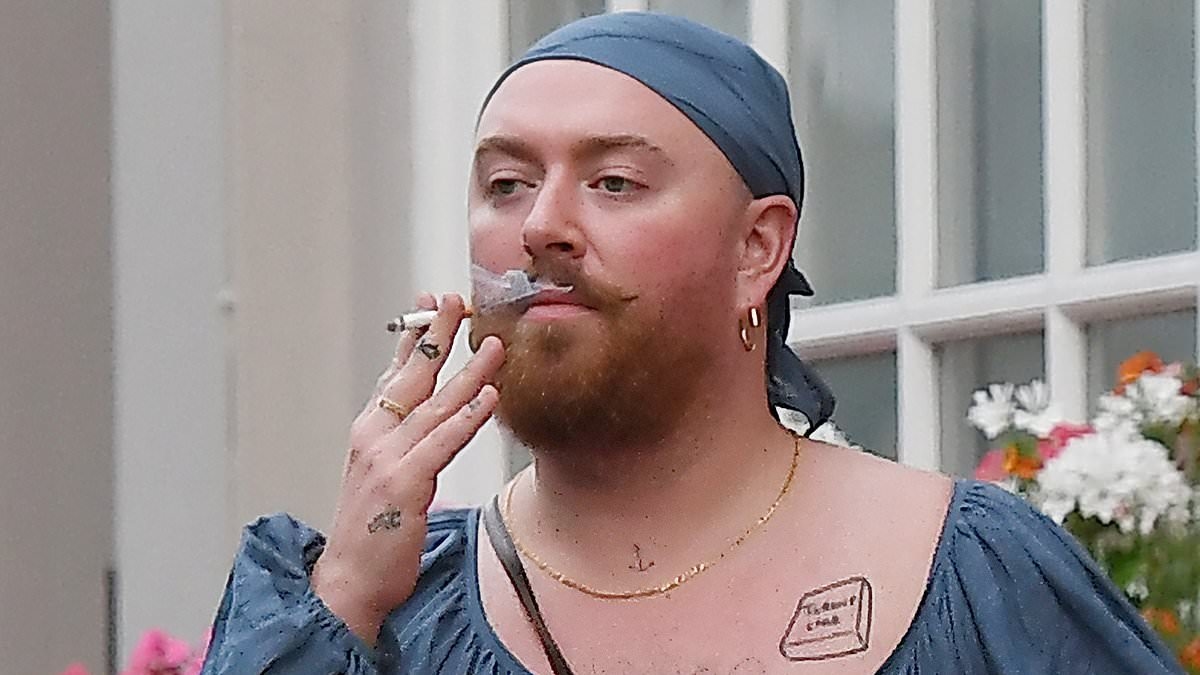 Sam Smith turns heads in floor-length navy dress and matching bandana as they puff on a cigarette in Notting Hill after releasing brand new single