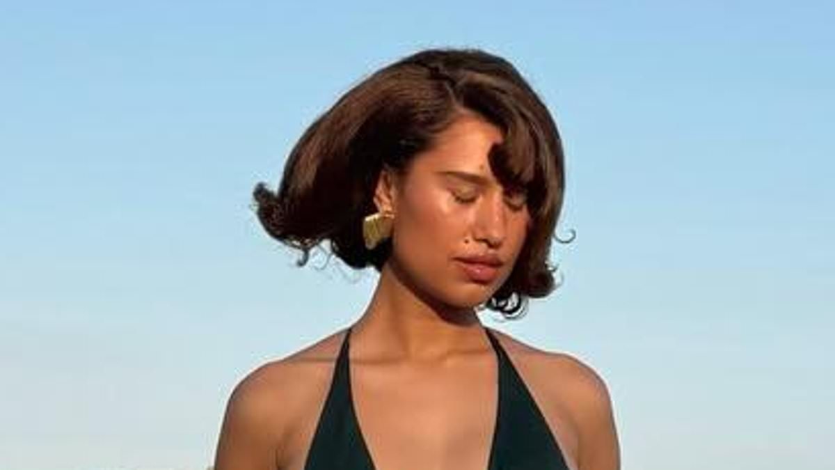 Raye shows off her incredible figure in a plunging black swimsuit as she announces new music with a candid message about industry pressures