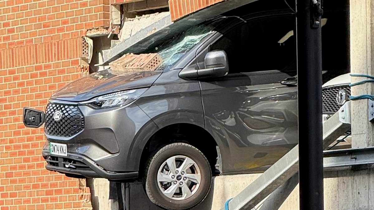 Pedestrians rushed to hospital after being hit by falling rubble when van ploughed through wall and was left dangling from car park building
