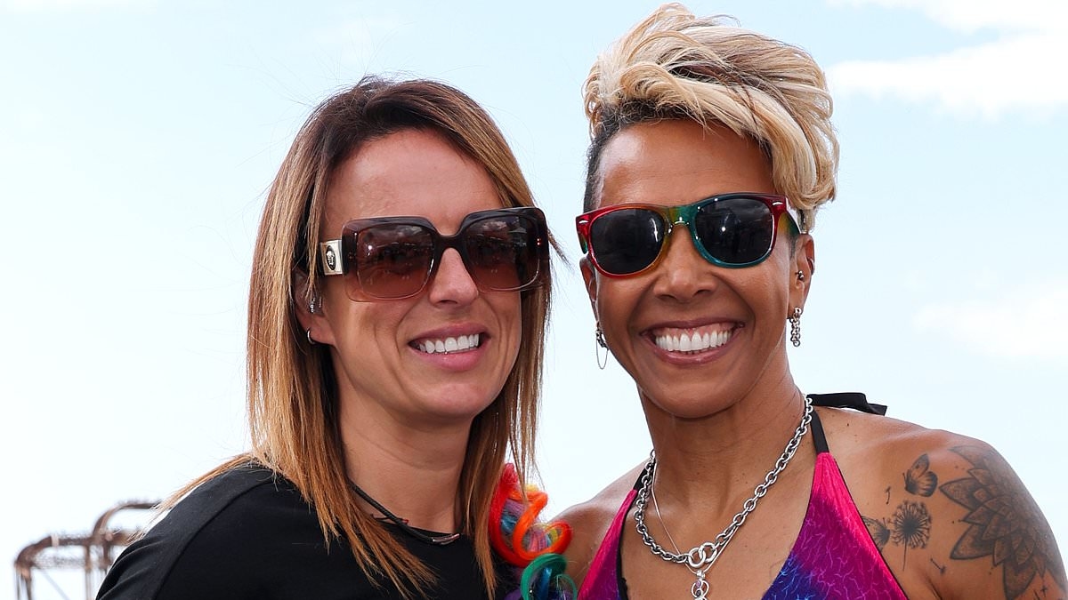 Dame Kelly Holmes cuts a stylish figure in a rainbow top and black leather shorts as she joins girlfriend Louise Cullen at Brighton Pride