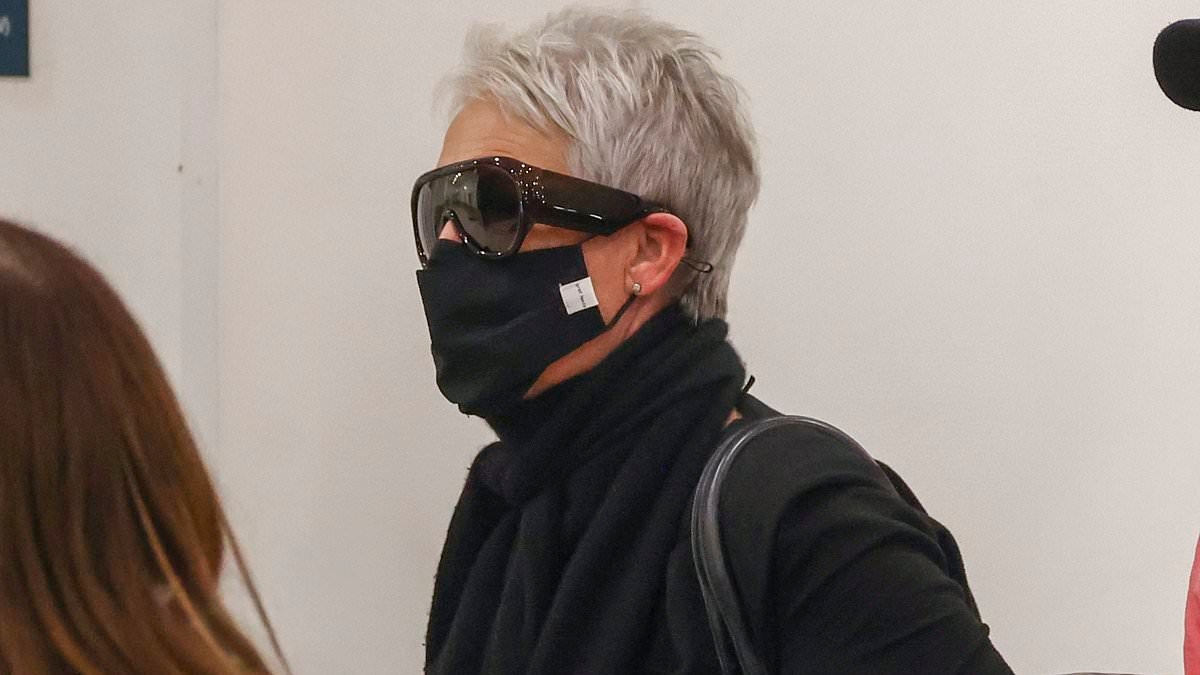 Guess who! Hollywood icon hides her face with a mask as she touches down at Sydney Airport