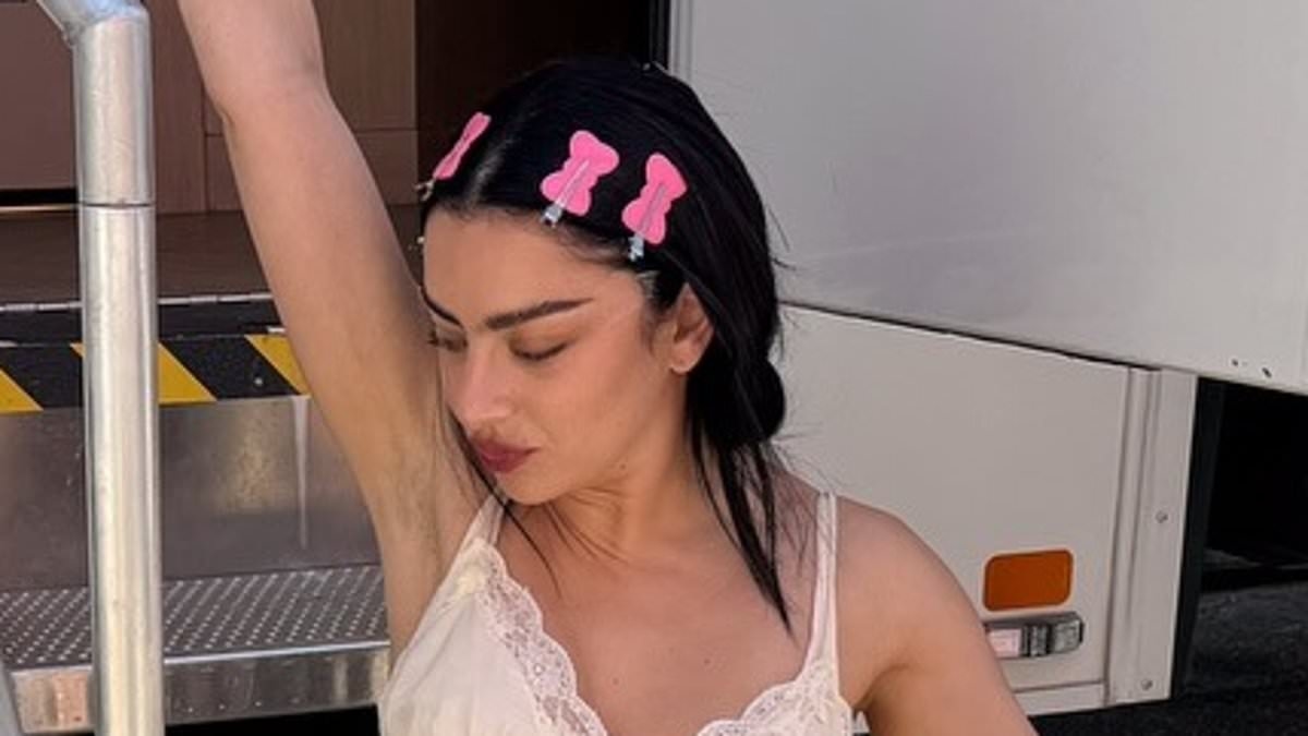 Charli XCX sets pulses racing as she flashes her bottom in a wet-look ensemble and dons a sheer slip while modelling her Converse line