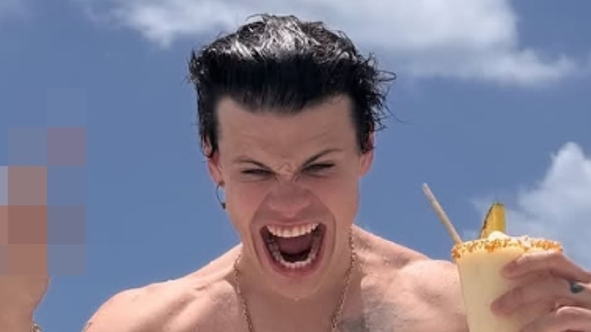Yungblud goes shirtless while unwinding in a trucker cap during beach holiday as rocker celebrates his 28th birthday - after paying tribute to Ozzy Osbourne