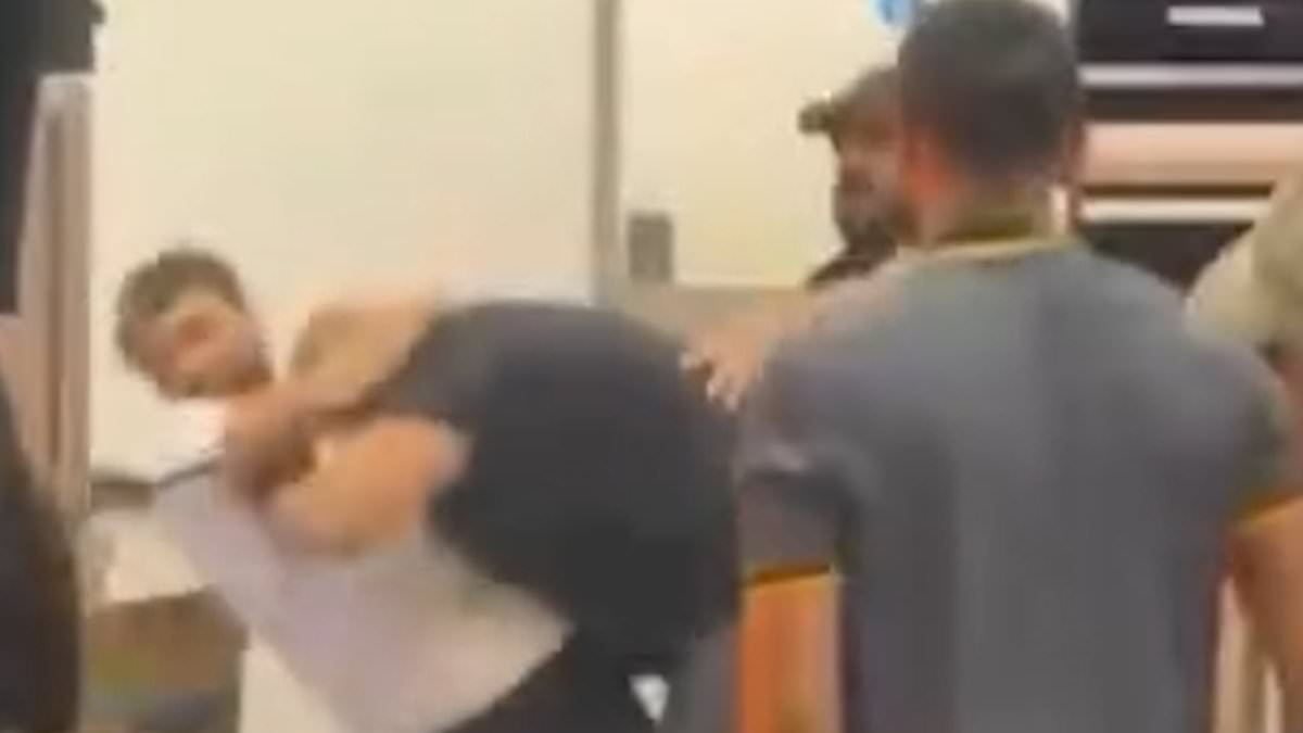 Moment McDonald's customer jumps over the counter and starts brawling with staff in London