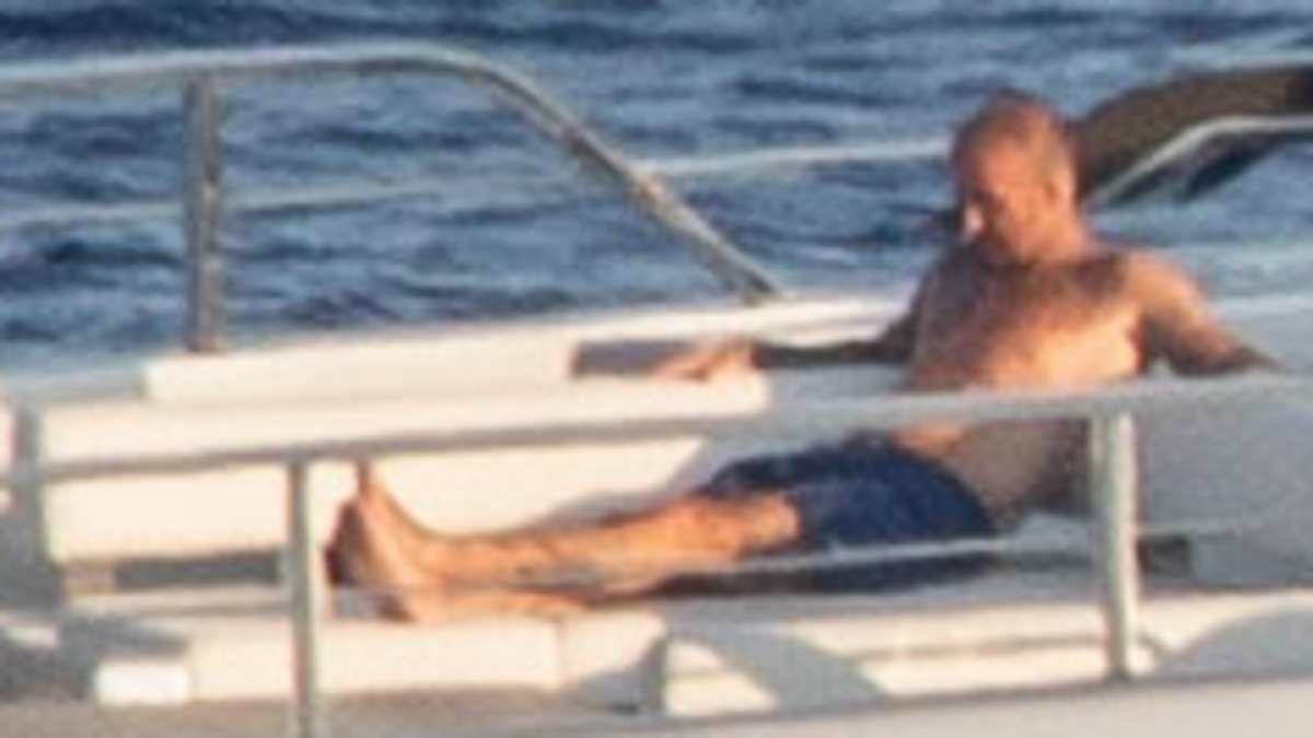 Shirtless David Beckham and wife Victoria continue soaking up the sun on their £16m superyacht amid lavish Italian getaway - after he was caught cheekily pinching her bottom