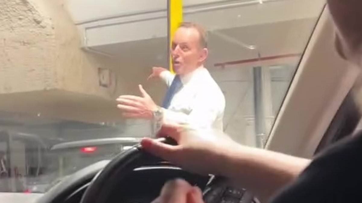 Bizarre moment former Australian prime minister Tony Abbott is seen directing traffic in a car park