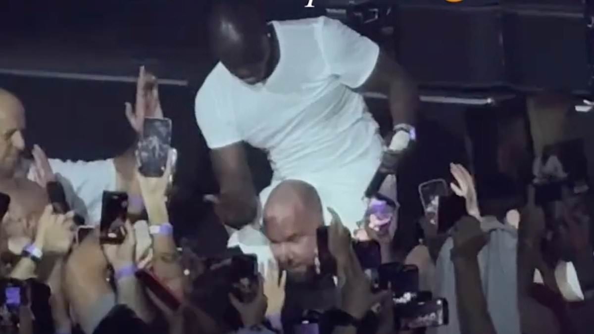 Akon attempts to ride a security guard like a horse as he climbs on his shoulders and slaps his head during performance in Russia