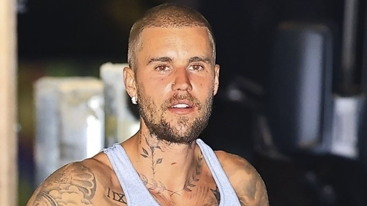 Justin Bieber displays his tattooed arms in a fitted tank top while smoking during date night with stylish wife Hailey in West Hollywood