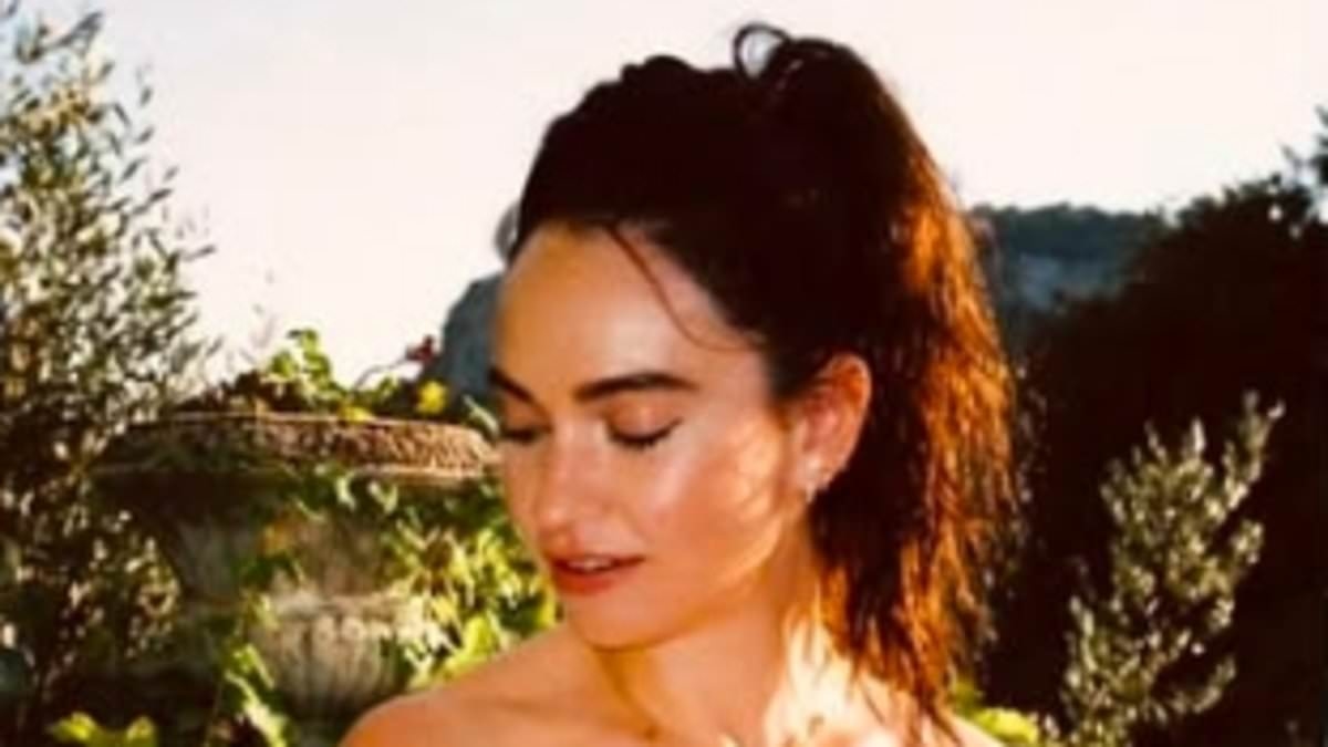 Lily James looks gorgeous in a pink striped bikini as she poses on a boat during sun-soaked summer trip
