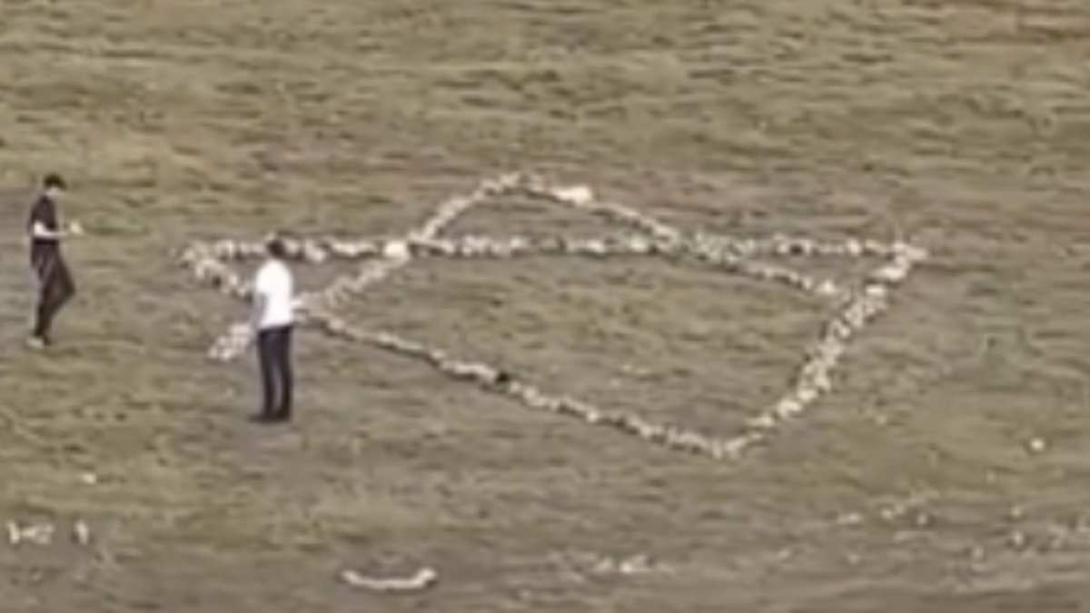 Moment Jewish holidaymakers dismantle hillside Christian cross and use stones to create giant Star of David instead