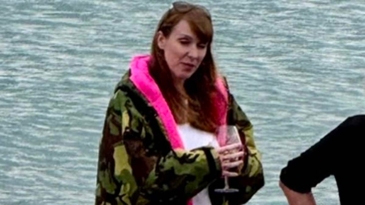 Raising her glass to a war on the middle classes? 'Woman of the people' Angela Rayner is snapped sipping rosé on the beach in £165 Dryrobe