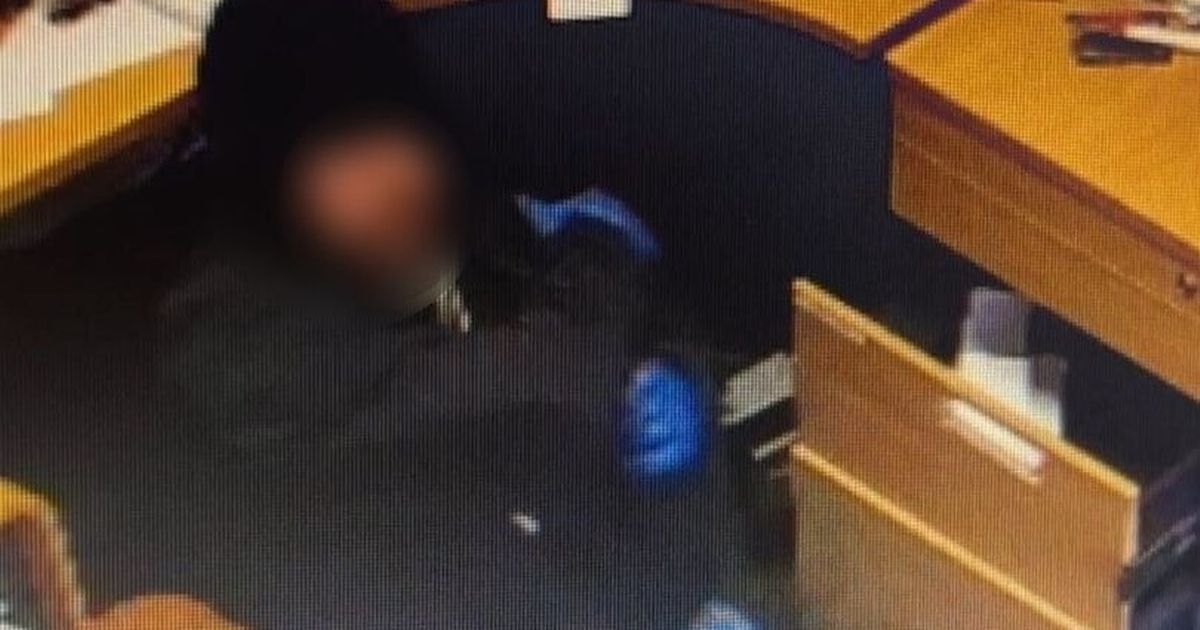 Crook wearing blue forensic gloves raids Scots restaurant offices for cash