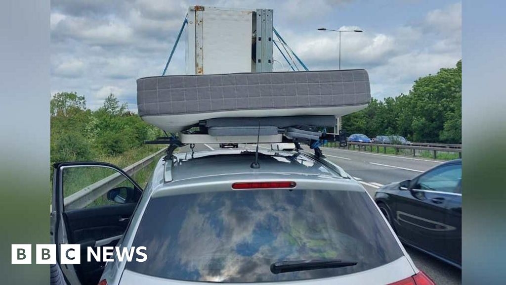 Car on M11 in Essex with fridge, mattress and table on roof