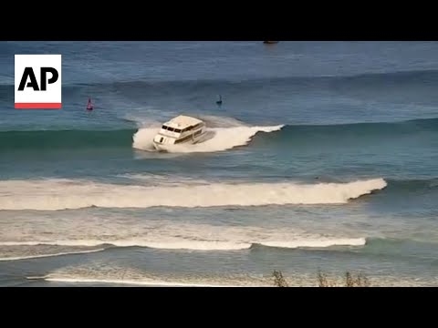 Yacht-sized passenger boat runs aground in high surf off Hawaii beach