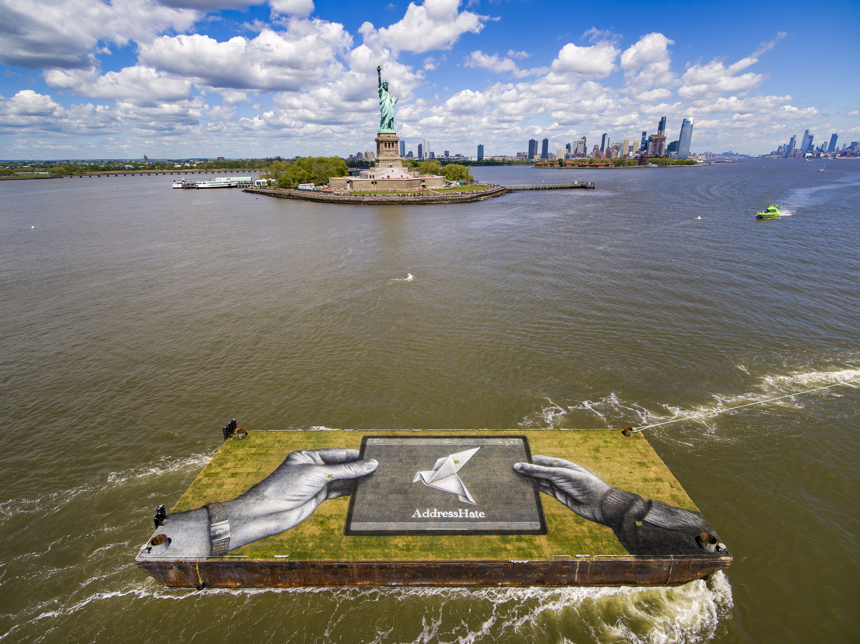 There's a massive, ephemeral mural calling viewers to ‘address hate' floating down the East River today