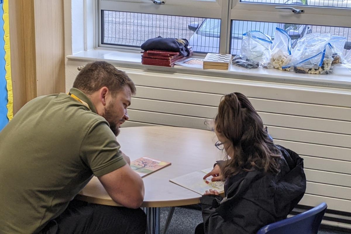 Volunteers help pupils at school through reading programme