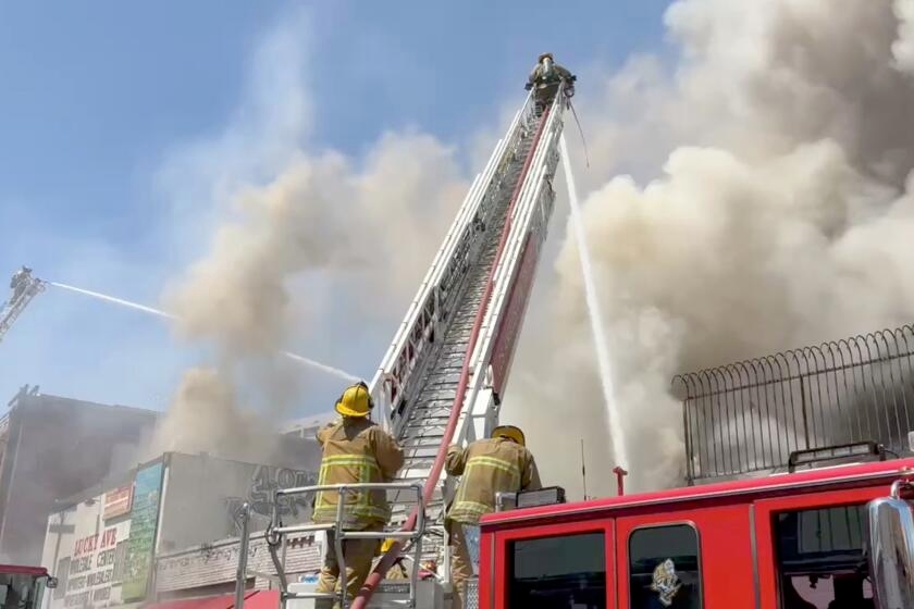 Nearly 100 firefighters battle large fire burning at downtown Los Angeles commercial building
