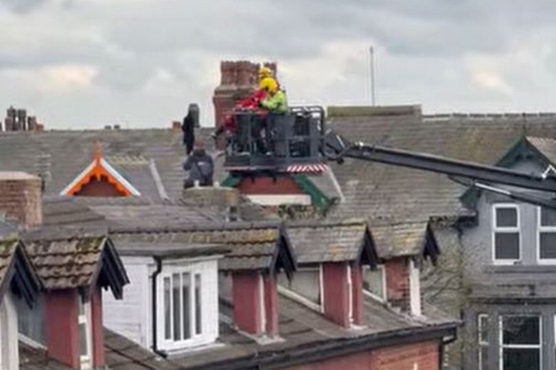 Police tape off street in stand-off after man scales roofs of homes