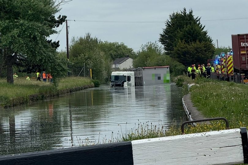 Lorry lands in CANAL after leaving the road in dramatic crash