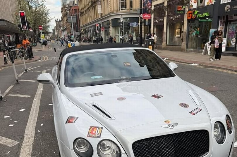 Police escort thousands of Lyon fans marching along Deansgate as £250k Bentley covered in stickers