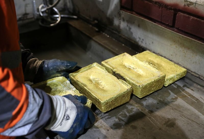 Gold gains on dollar weakness, safe-haven demand