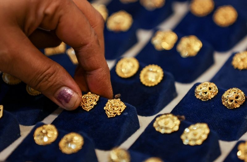 Gold falls over 1% on dollar uptick, profit taking