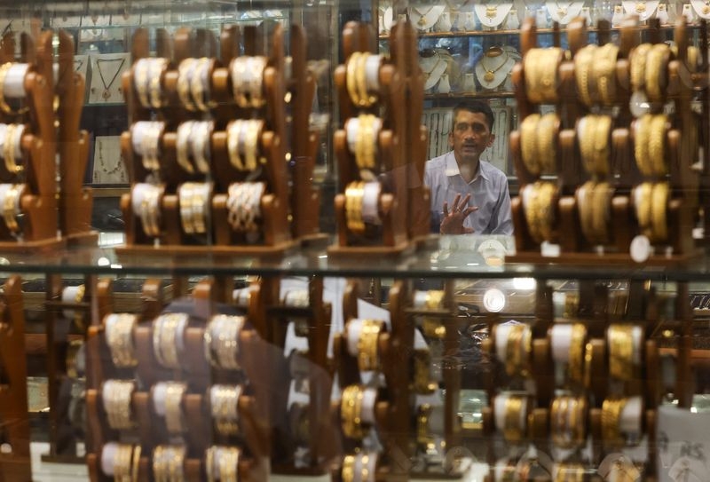Gold hits one-week low as investors cash in, trade war fears persist
