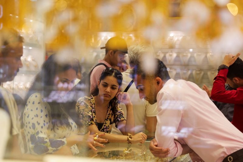 Gold flat as easing trade tensions offset support from weak dollar