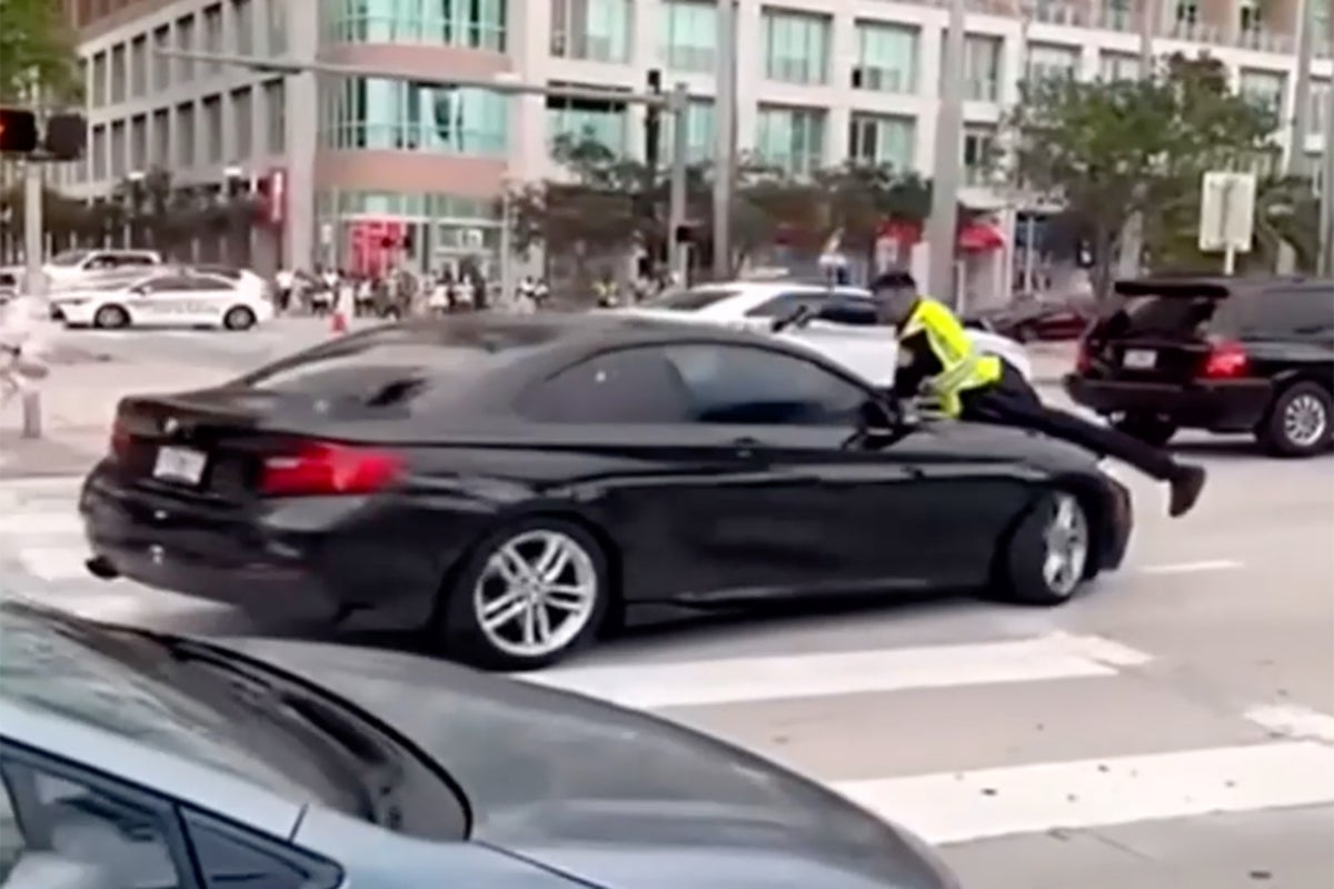 Shocking video shows cop on the hood of a moving car before shooting suspect