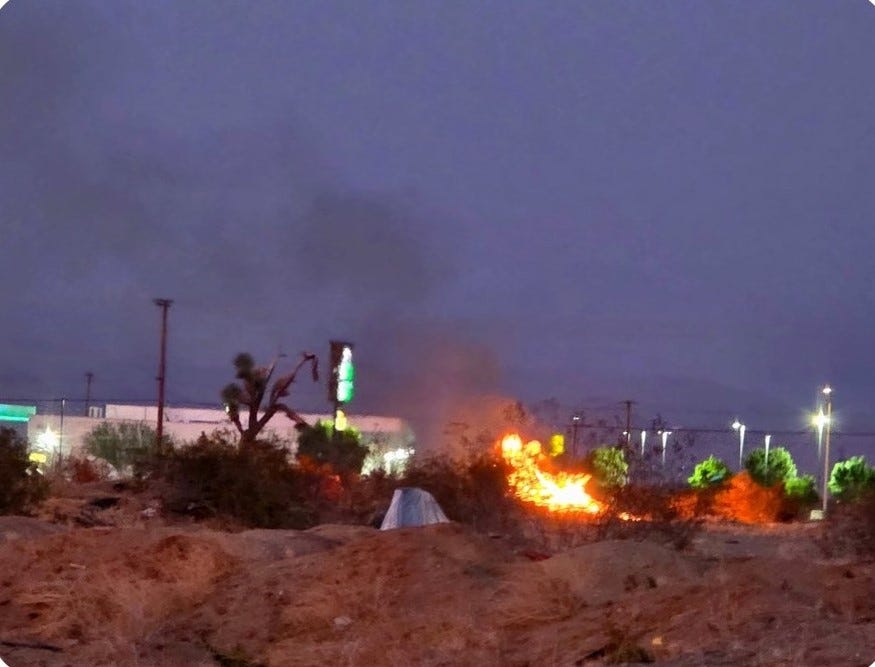 Fire breaks out behind Adelanto liquor store as police search for armed man