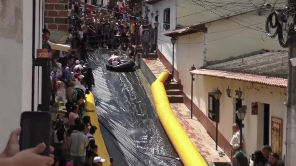 Colombian town turns main street into giant slide to boost image