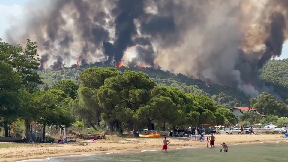 Beach-goers watch as wildfire burns in Greece's Halkidiki