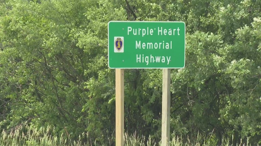 Behind the veteran designating Winnebago County's Highway 21 as Purple Heart Memorial Highway