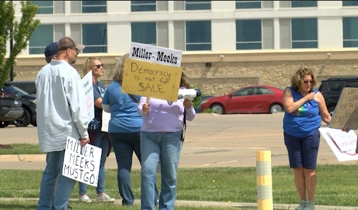 Protesters wait outside Rep. Miller-Meeks' event in Davenport