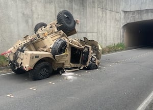 Military vehicle drifts over interstate wall, crashes onto street below