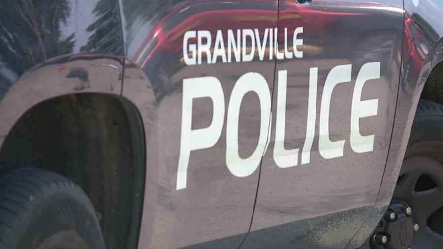 Grandville PD: Child, mom hospitalized after sedan trapped under trucks
