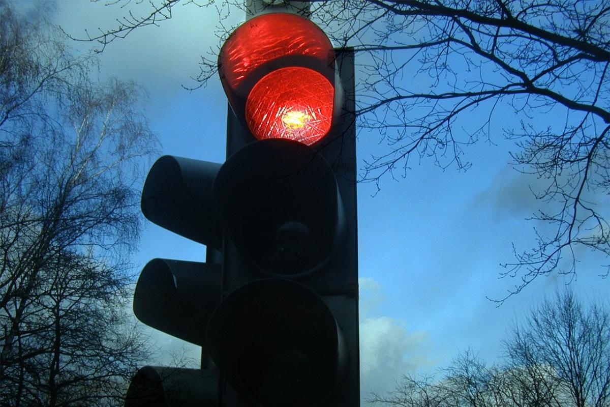 Should I go through a red light if an ambulance is behind me?