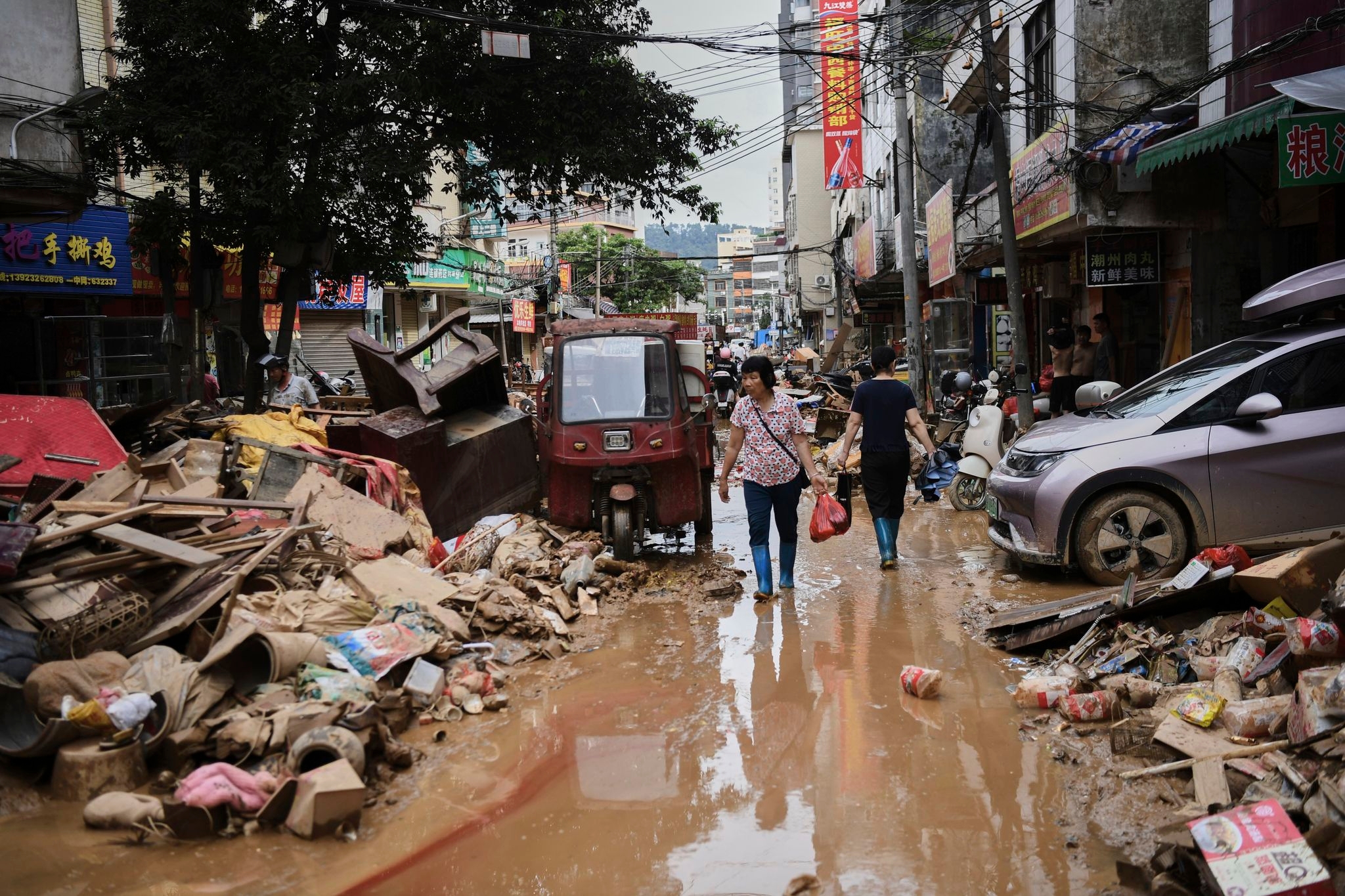 A river overflows in southern China, stranding people and turning streets into canals