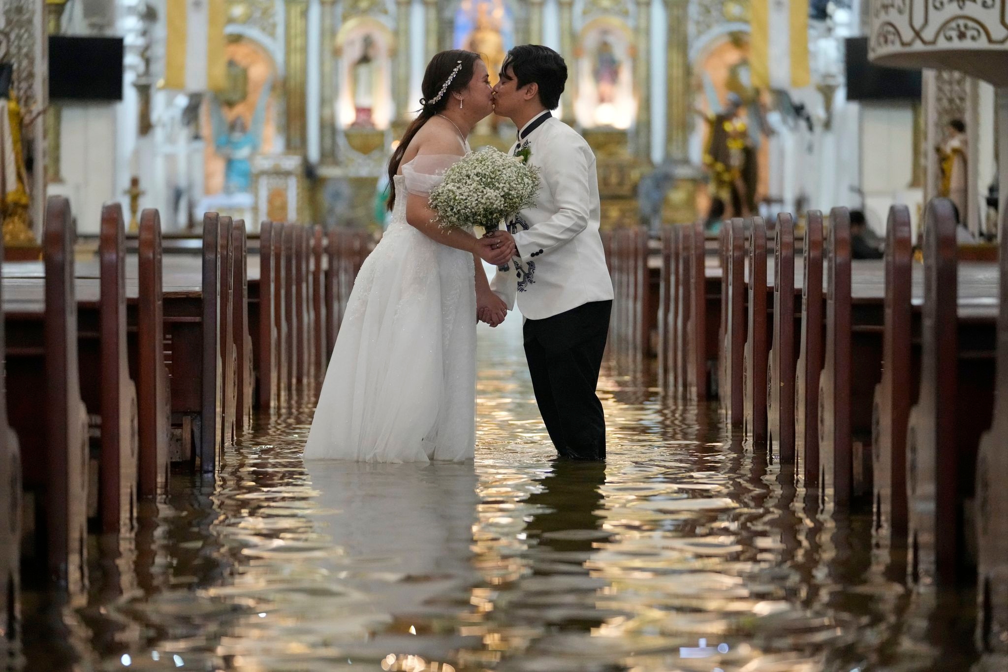 Photos show a Filipino couple walking down a flooded aisle on their wedding day