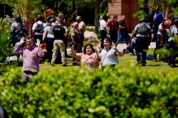Emergency alerts, desks barricading doors, shoes abandoned in the grass