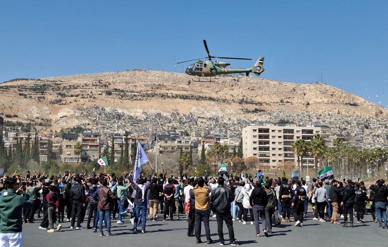 السوريون يحيون ذكرى الثورة لأول مرة في دمشق.. ومروحيات الجيش تلقي الورود (شاهد)