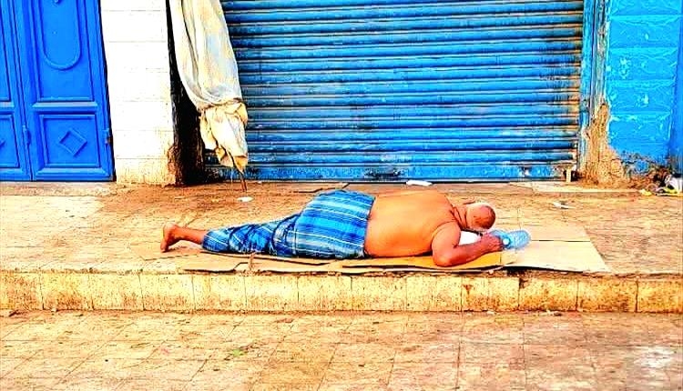 صورة من قلب عدن.. رجل يفترش الرصيف هربًا من لهيب الصيف وانقطاع الكهرباء المستمر