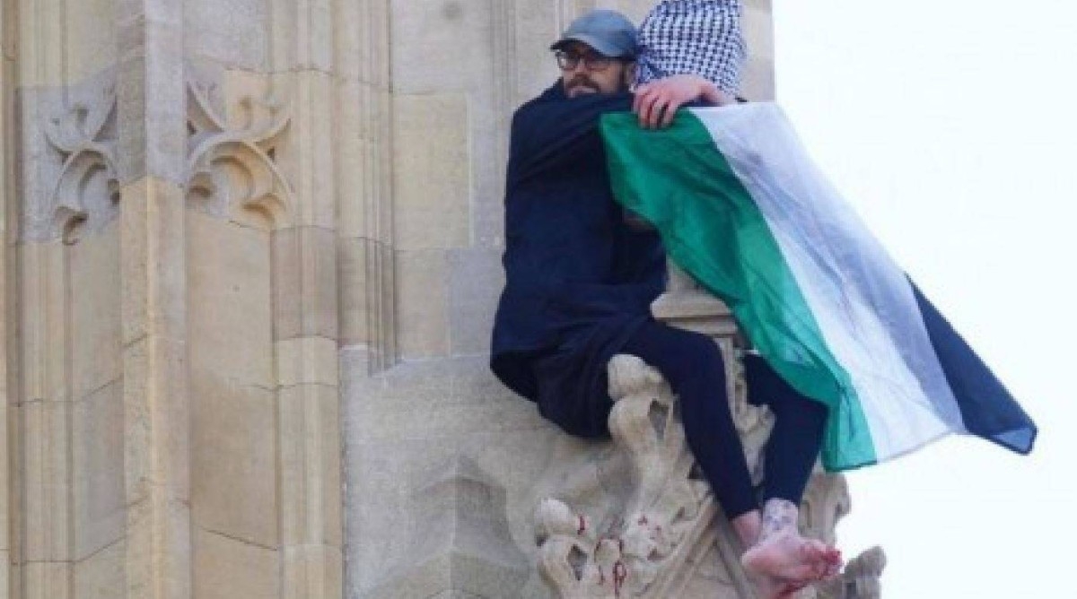 رجل يتسلق برج بيج بن في لندن رافعاً علم فلسطين