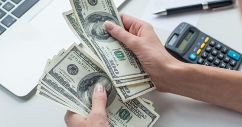 الدولار يهبط لكنه يتمكن من الاحتفاظ بارتفاع أسبوعي طفيف