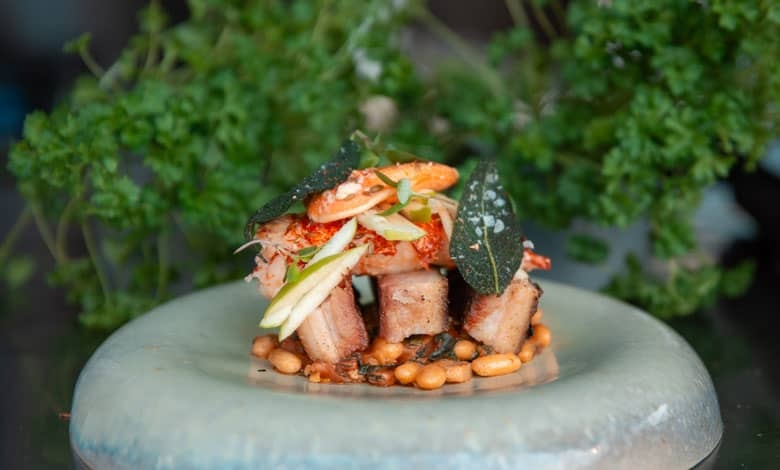 Poached lobster and pork belly served on cannellini beans
